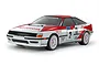 A Tamiya 1/10 scale RC Toyota Celica GT-Four ST165 rally car model, featuring a white and red livery with racing decals on a white studio background.