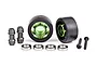 Traxxas green aluminium wheelie bar wheels with black rubber tires, bearings, and mounting hardware on a white background.
