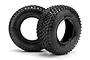 Two black HPI Racing short course RC tyres with aggressive tread patterns, shown against a white background.