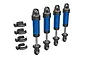 Four blue anodized aluminium Traxxas GTM shock absorbers with black plastic caps and four matching black plastic spring preload spacers.