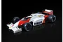 A studio shot of a 1/12 scale McLaren MP4/2C Formula 1 model car in white and red livery with Shell and Goodyear branding on a black reflective background.