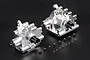 Two silver aluminium RC gearbox housings with black drive cups and a collection of small black screws on a black background.