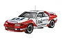 A studio shot of a finished 1/12 scale Fujimi Unisia Jecs Nissan Skyline R32 plastic model kit, featuring the iconic red and white racing livery.