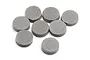 Eight small, circular grey foam spacers arranged on a white background.