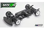 A high-angle studio shot of a Mugen Seiki MTC2R 1/10 scale electric touring car chassis, featuring a carbon fiber deck, brushless motor, and foam bumper.