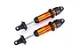 Two Traxxas orange anodized aluminium GTX shock absorbers without springs, shown against a plain white background.