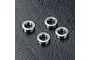 Four small metal shielded ball bearings arranged on a black textured surface.