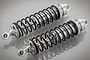 Two Rovan silver aluminium adjustable RC car shock absorbers with black springs on a grey reflective surface.