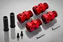 A set of Rovan red anodized aluminium extended wheel hex adapters with black sleeves, pins, and screws on a grey background.