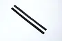 Two thin strips of black adhesive hook and loop fastener material laid diagonally on a white background.