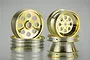Four gold-plated RC buggy rims from Tamiya, featuring a classic multi-hole design, arranged in two stacks against a light grey background.