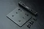 MST black aluminium C crossmember set including a flat plate, a crossmember bar with MST logo, and several small black screws on a dark textured surface.