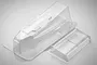 Clear, unpainted polycarbonate body shell and wing for a Tamiya Super Hotshot RC buggy, shown from a high angle on a light grey background.