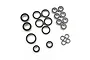 A collection of various sized metal ball bearings with black rubber seals arranged on a white background.