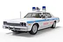 A 1/32 scale Scalextric Dodge Monaco Chicago Police slot car from The Blues Brothers, featuring a white body, blue stripes, and roof-mounted sirens.
