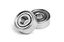 Two small metal shielded ball bearings resting on a white surface.