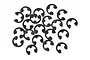 A collection of twenty small black metal E-clips scattered on a white background.