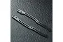Two carbon fibre RC chassis upper deck components with metal mounting inserts, displayed on a dark textured surface.