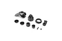 A collection of black plastic RC shock absorber parts including a shock cap, spring collar, pistons, and small mounting screws on a white background.