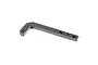 An L-shaped carbon fibre battery width plate for an RC car, featuring a woven texture and multiple mounting holes.