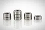 Eight metal shielded ball bearings arranged in small stacks on a white reflective surface.