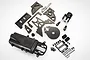 A Rovan petrol to electric conversion kit containing various metal chassis plates, a battery box, steering assembly, and hardware on a white background.