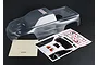 Clear unpainted Traxxas Revo 3.3 RC truck body shell with a decal sheet and instruction paper on a black background.