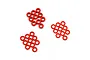 A collection of small red anodized aluminium flat washers arranged in three loose groups on a white background.