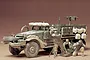 A 1/35 scale Tamiya model of a U.S. M21 Mortar Carrier half-track with three painted soldier figures operating a mortar in front of the vehicle.