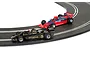 Two 1/32 scale Scalextric Formula 1 slot cars racing on a curved track, featuring a black John Player Special and a red Parmalat Alfa Romeo.
