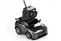 A 1/64 scale grey FMS RC car with a black FPV camera mounted on its roof against a white background.