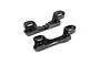 Two black anodized aluminium upper clamps for RC cars, featuring mounting holes and a serrated edge, isolated on a white background.