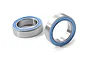 Two metal ball bearings with blue rubber seals isolated on a white background.