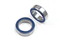 Two metal ball bearings with blue rubber seals on a plain white background.