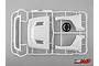 A white plastic sprue containing various 1/10 scale RC truck cab parts and a black steering wheel, set against a plain grey background.