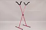 A red aluminium adjustable V2 airplane stand with black foam-padded cradles against a plain grey background.