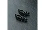 A group of ten black metal countersunk hex head screws arranged on a textured black surface.