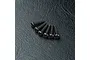 Six black button head screws with hex drive sockets arranged on a textured black surface.