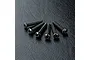 Six black metal button head screws with hex sockets arranged in a fan shape on a textured black surface.