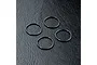 Four black rubber O-rings arranged on a textured black surface.