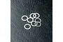 A small pile of eight thin, silver-coloured metal washers resting on a black textured surface.
