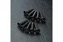 A set of ten black metal countersunk hex head screws arranged on a textured black surface.