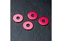 Four small, circular, red anodized metal wheel hub spacers arranged on a black textured surface.