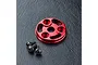 A red anodized aluminium spur gear cover for an RC car, accompanied by three small black hex screws on a black textured surface.