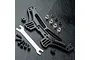 MST black aluminium rear shock mount set including a shock tower, adjustment tool, and various mounting hardware on a black textured surface.