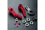 MST red aluminium and carbon fibre steering assembly parts including steering arms, bearings, screws, and spacers on a black textured surface.