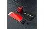 MST red aluminium ESC mount with carbon fibre plate, double-sided tape, and screws on a textured black surface.