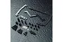 MST carbon fibre short battery mount kit with black aluminium hardware, including various screws, spacers, and mounting plates on a dark textured surface.