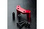 MST red anodized aluminium steering arm mount with two black metal spacers and four black hex head screws on a black textured surface.