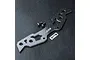 MST carbon fibre bumper support plate with two small metal screws and a small MST logo sticker on a black textured background.
